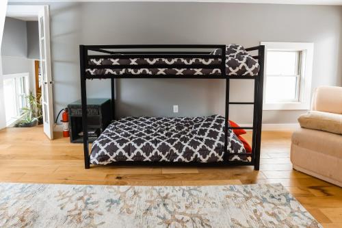 a black bunk bed in a room with a rug at Chasing the Slopes in North Woodstock