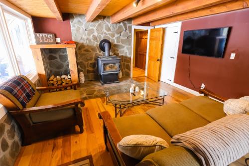 a living room with a couch and a wood stove at Chasing the Slopes in North Woodstock