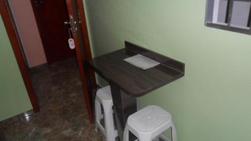 a bathroom with a small table and a stool at Trilhos Hotel in Sao Paulo