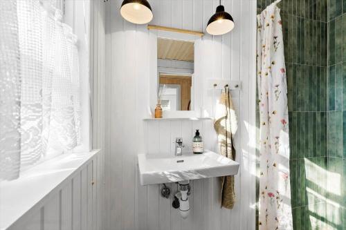 a white bathroom with a sink and a mirror at 8566-Grenaa-Askevej-17 in Grenå Strand