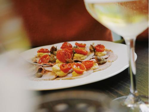 a plate of food next to a glass of wine at 21 House of Stories Città Studi in Milan