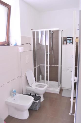 a white bathroom with a toilet and a shower at Dentro le mura, natura relax e cultura in LʼAquila