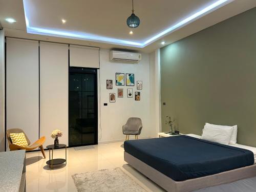 a bedroom with a bed and a desk and chairs at Ellie House Phuket Old Town in Ban Rangeng
