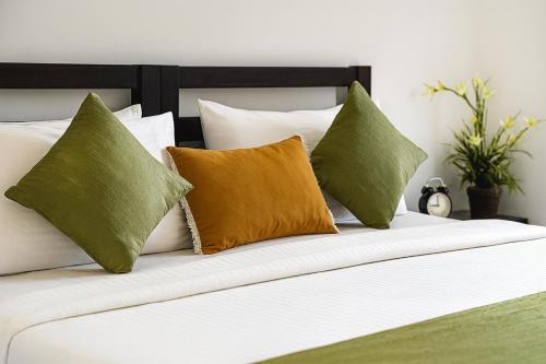 a white bed with four pillows on it at Oslo Ganges by Around stays, Tapovan in Rishīkesh