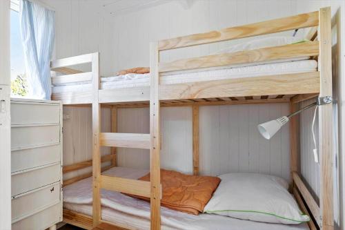 a bedroom with two bunk beds and a lamp at 5700-Svaneke-Duebakken-9 in Svaneke