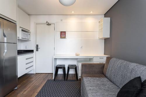 a living room with a couch and a kitchen at Flat Parque do Ibirapuera - Jardins in Sao Paulo