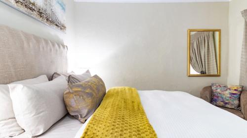 a bedroom with a bed with a yellow blanket on it at High Court Self Catering Apartments in Nelspruit