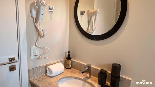 a bathroom with a sink with a blow dryer at White 2880 - Pinheiros in Sao Paulo