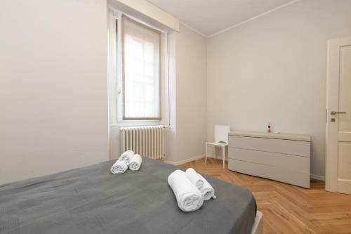 a white bedroom with a bed and a window at Living Salò in Salò