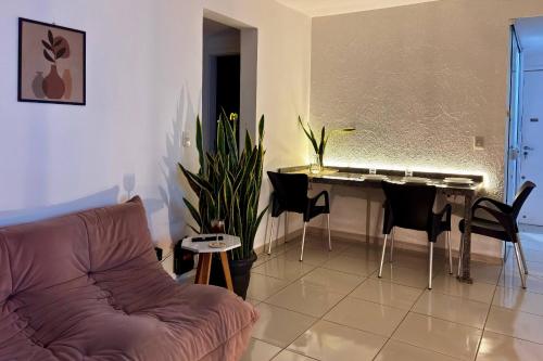 Una sala de estar con un sofá y una mesa con un piano en Vista do pôr de sol, 5 min a pé da praia Tartarugas, 3 supermercados e igreja universal, super arejado, en Rio das Ostras