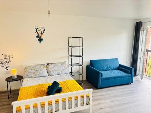 a bedroom with a bed and a blue couch at London Economy Stay at 31 in London