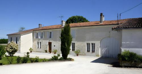 Saint-Maurice-de-TavernoleにあるLe Vieux Noyerの白いガレージ付きの大きな白い家