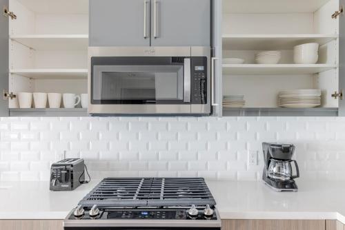 a kitchen with a stove and a microwave at Blueground Milpitas pool nr Ed R Levin Park SFO-2021 in Milpitas