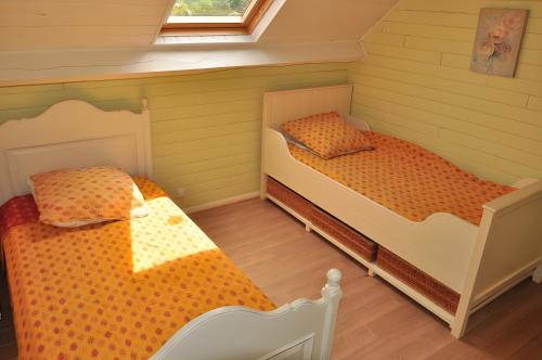 2 camas individuales en una habitación con paredes verdes en Gîtes de Lopéau - jusqu'à 8 invités, en Plogonnec