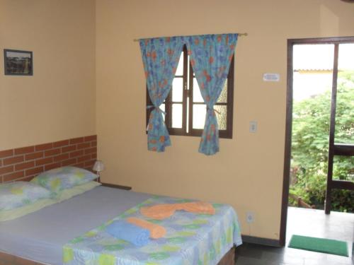 1 dormitorio con cama y ventana en Estalagem Tatuí, en Cabo Frío