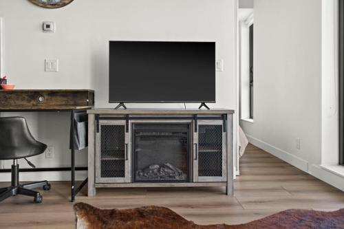 a living room with a television and a fireplace at GLOBALSTAY Downtown Calgary Apartments in Calgary