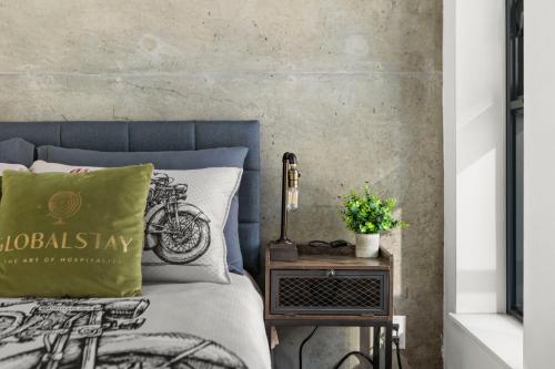 a bed with a green pillow and a side table at GLOBALSTAY Downtown Calgary Apartments in Calgary