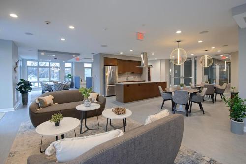a living room with a couch and tables and a kitchen at Blueground Bleachery pool nr Charles River BOS-1251 in Bemis