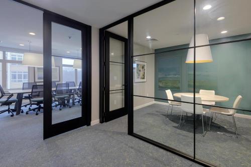 a conference room with glass walls and a table and chairs at Blueground Bleachery pool nr Charles River BOS-1251 in Bemis
