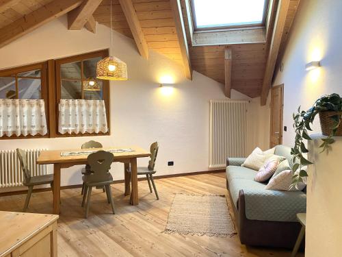 a living room with a table and a couch at Mansarda Ai Tigli in Castello di Fiemme