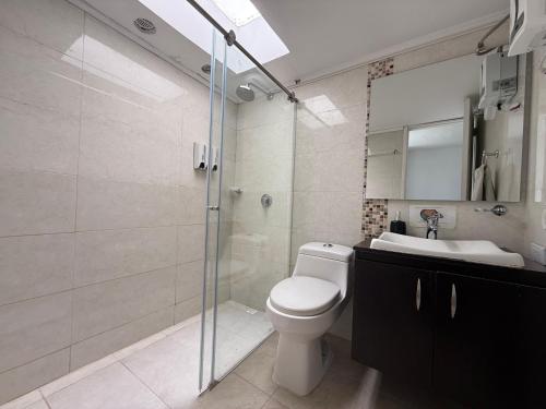 a bathroom with a toilet and a shower and a sink at One Fourteen Rooms in Bogotá