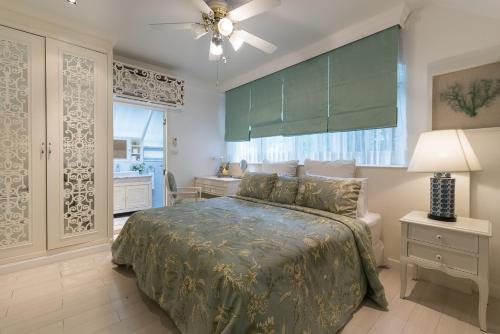 1 dormitorio con 1 cama con colcha verde en Baan Hua Hin 4 Bedroom Luxury Villa by Passionata Collection, en Hua Hin