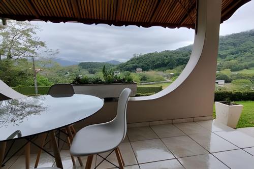 a dining room with a table and chairs and a large window at Casa Central com Vista Exclusiva in Pomerode