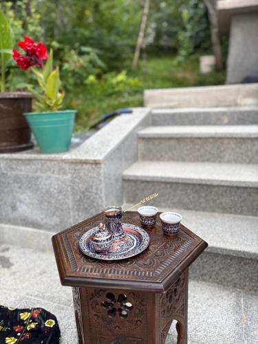 a small table with a plate and cups on it at Zenn Apartments Sarajevo in Sarajevo