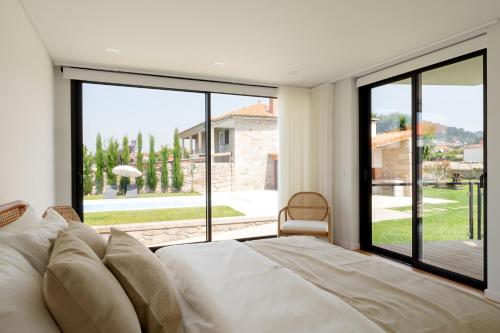 a bedroom with a bed and a large glass window at Casa do Avô in Viana do Castelo
