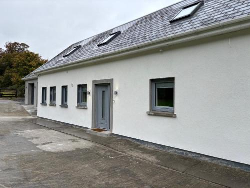 a white building with a blue door and windows at The Overlook in Cahir