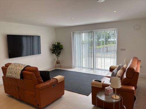 a living room with two couches and a flat screen tv at The Overlook in Cahir