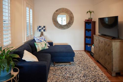 a living room with a blue couch and a television at Spacious 3BR Potrero Hill Home Free Parking Minutes to Moscone & Caltrain for Super Bowl in San Francisco
