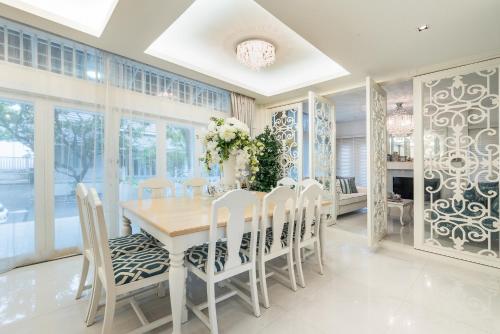 a dining room with a wooden table and chairs at Baan Hua Hin 4 Bedroom Luxury Villa by Passionata Collection in Hua Hin