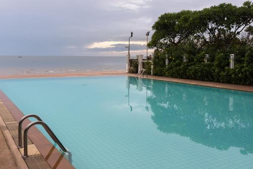 a large swimming pool with a view of the ocean at Baan Hua Hin 4 Bedroom Luxury Villa by Passionata Collection in Hua Hin