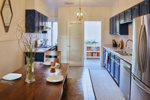 a kitchen with a wooden table and blue cabinets at Spacious 3BR Potrero Hill Home Free Parking Minutes to Moscone & Caltrain for Super Bowl in San Francisco
