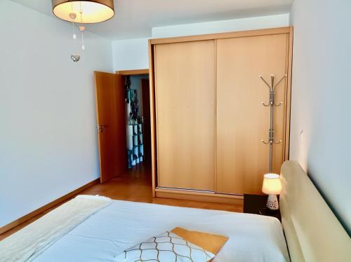 a bedroom with a bed and a closet at Sunny Little Sister Apartment - 7 min walking from the sea in Machico