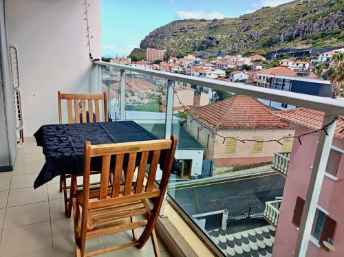 a table and chairs on a balcony with a view at Sunny Little Sister Apartment - 7 min walking from the sea in Machico