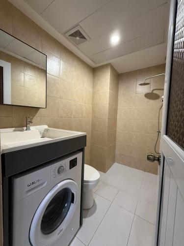 a bathroom with a washing machine and a sink at Cozy 1BR in Zef, Near Anjo World Wifi, Pool, Gym in Minglanilla