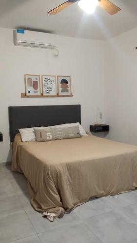 a bedroom with a bed with a brown blanket at Sol & Río Refugio Serrano in Villa Las Rosas