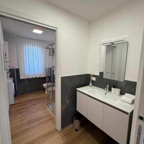 a white bathroom with a sink and a mirror at Residence Corte Astrale in Sesto al Reghena