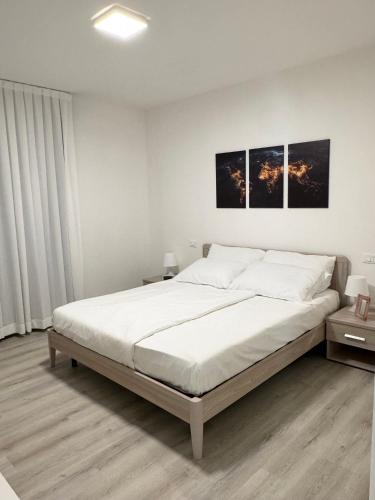 a bedroom with a large bed with two pictures on the wall at Residence Corte Astrale in Sesto al Reghena
