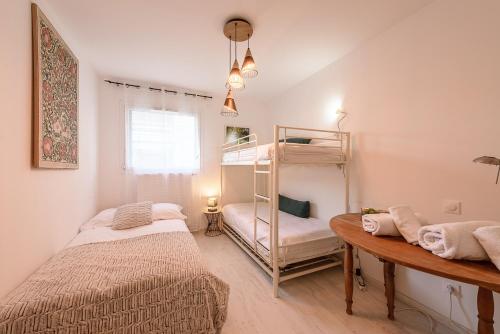Un dormitorio con dos literas y una mesa. en Le Green Garden - Rez de jardin ensoleillé à quelques pas du lac, en Saint-Jorioz