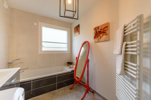 Un baño con bañera, lavabo y espejo. en Le Green Garden - Rez de jardin ensoleillé à quelques pas du lac, en Saint-Jorioz