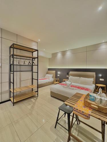 a large room with two beds and a table at Casa Casa in Semporna