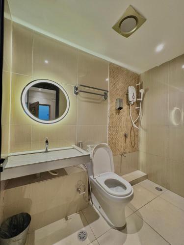 a bathroom with a toilet and a sink and a mirror at Casa Casa in Semporna