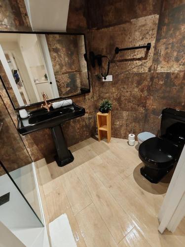 a bathroom with a black toilet and a sink at TuApartamento Chapitela 16 by Clabao in Pamplona