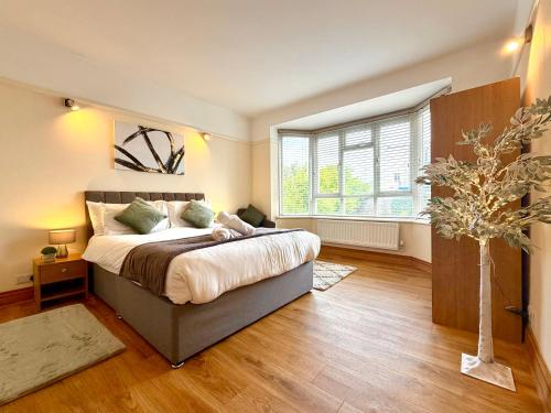 a bedroom with a large bed and a window at Spacious Three Bedroom in Bournemouth - 5 Mins Walk to Beach - Free Parking in Bournemouth