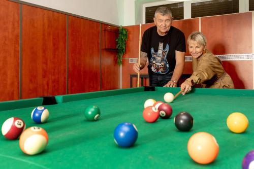 a man and a woman playing a game of pool at Butenas Hotel Tyla in Biržai