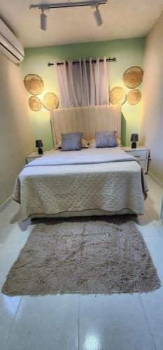 Los MameyesにあるGilmar Stay, A pasos de la Avenida Españaの大きなベッドとラグのある寝室