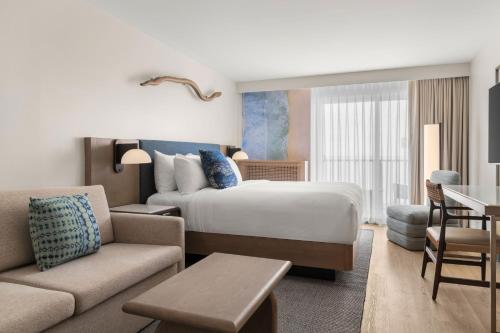 a hotel room with a bed and a living room at The Seahaus Hotel, Atlantic City Boardwalk, a Tribute Portfolio Hotel in Atlantic City